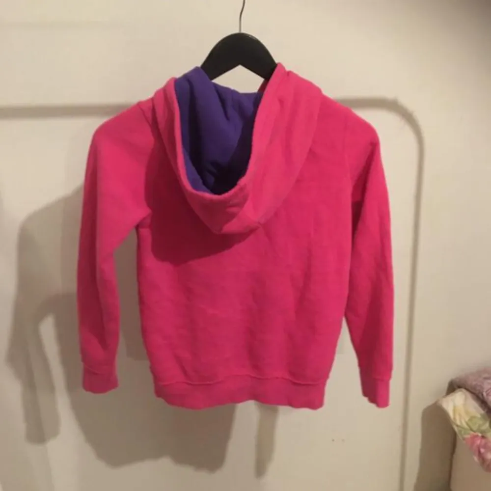 Säljer en snygg rosa hoodie med texten 'Orig. Dept PA' på framsidan. Den har en dragkedja och en mysig luva med lila insida. Perfekt för en avslappnad stil och passar bra till både jeans och leggings. Använd ett par gånger men i mycket bra skick!. Tröjor & Koftor.