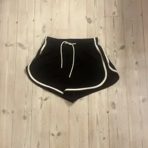 Säljer ett par svarta shorts från Gilly Hicks i mycket bra skick. De har en vit dragsko i midjan och vita detaljer längs kanterna. Perfekta för sommarens alla aktiviteter eller bara att chilla i. Superbekväma och stilrena!