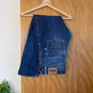 Blå jeans från Edwin - Säljer ett par klassiska blå jeans från Edwin, modell ED-55. De har en relaxed fit och är tillverkade i slitstarkt denim. Perfekta för en avslappnad stil med fem fickor och knappgylf.