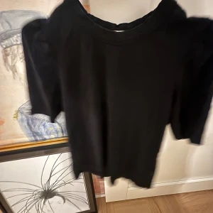 Svart tröja från Rodebjer - Säljer en stilren svart tröja från Rodebjer. Tröjan har en klassisk design med trekvartsärmar och rund halsringning. Perfekt för en minimalistisk look.