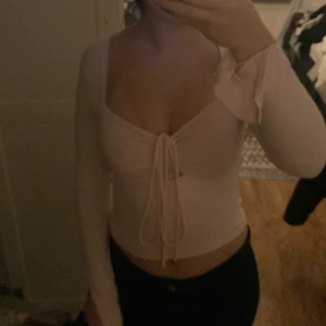 Rosa topp - Säljer en söt rosa topp med knytning framtill. Blusen har långa ärmar och en djup v-ringning. Passar bra till både jeans och kjol. Köparen betalar frakt!!!