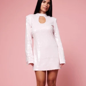 Ljusrosa paljettklänning - Snygg ljusrosa klänning med paljetter och långärmad design. Den har en unik nyckelhålsdetalj vid halsen som ger en elegant touch. Perfekt för att glittra på festen!                 Klänningen är en specialkolektion fråb BikBok och är i helt nyskick.