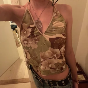 Blommig halterneck topp - Cool topp med en liten knytning på ena sidan. Skulle gissa att den är  xs/s.