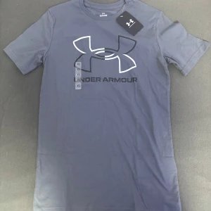 Under Armour T-shirt  - Snygg mörkblå oanvänd  t-shirt från Under Armour med deras ikoniska logga tryckt på bröstet. Perfekt för träning eller en avslappnad dag. Tillverkad i ett mjukt och bekvämt material. Köpt för 450