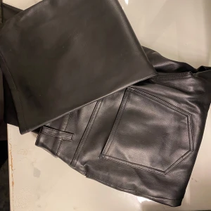Svarta skinnbyxor från Bik Bok - Snygga svarta skinnbyxor från Bik Bok i storlek S. Byxorna har en knapp och dragkedja framtill samt fickor bak. Perfekta för en stilren look.