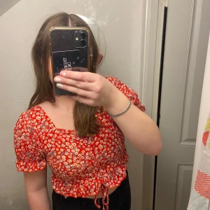 Röd-blommig topp - Sött röd-blommig topp som är justerbar framtill❤️Den har puff-ärmar som sitter åt nedtill. Aldrig använd❤️