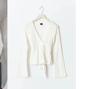 Vit topp med knytband - Vit fin tröja från Gina tricot som man kan knyta i ryggen. Ärmarna är även lite utsvängda. Älskar tröjan men den är tyvärr för stor😊jag har använt den3-5 gånger.