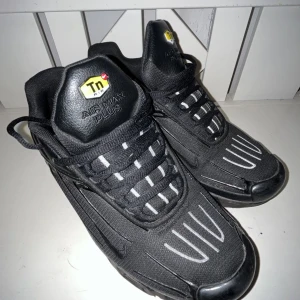 Svarta Nike Air Max Plus - Säljer ett par svarta Nike Air Max Plus med klassisk design och bekväm passform. Skorna har snörning och en stilren look med Tn Air-logga på plösen. Perfekta för dig som gillar en sportig stil.