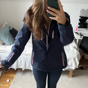 Skidset från swedemount  - Snygg mörkblått skid set från swedemount med rosa dragkedjor och detaljer. Perfekt nyskick och inga defekter. Endast använda en skidresa. Köp antingen separat jacka eller byxor för 700kr (nypris 1200 vardera). Eller både byxor och jacka för 1200kr 💘Storlek 38! Pris kan möjligtvis diskuteras.