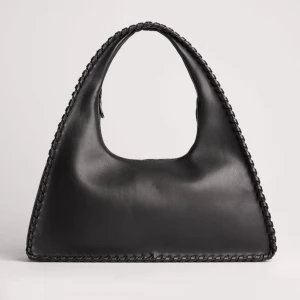 Svart axelväska med flätade detaljer - Säljer nu denna super snygga väska jag köpte från NA-KD i höstas pga för lite plats i min garderob. Orginalpris: 499kr.  HELT NY ALDRIG ANVÄND. Perfekt mellan storlek på väskan, inte för stor inte för liten.