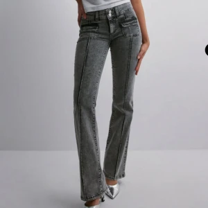 Grå bootcut jeans - Snygga grå bootcut jeans med mid waist och dubbla knappar. Perfekta för en trendig look med en bekväm passform. Passar utmärkt till både sneakers och klackar.