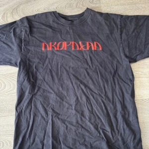 drop dead tshirt graphic tee - OBS varan ligger ute på vinted också så skicka dm innan utifall jag inte hunnit tagit bort om den blivit såld!!! svart graphic tee från drop dead, ca 2020? storlek M men tycker den är lite oversized så kanske mer som en L. kan va lite utstretchad i halsen och trycket är lite sprucket men annars bra skick.