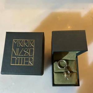 Örhänge Queen of chaos från Maria Nilsdotter. - Örhänge Queen of chaos från Maria Nilsdotter. Mycket gott skick. Nypris 2795k kr. Mitt pris 1500 kr.