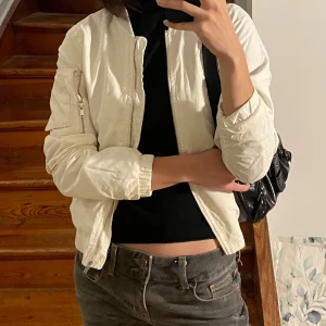 vit bomberjacka från Pull&Bear - tunn creme/vit bomberjacka från Pull&Bear med fickor på ärmen och sidorna!