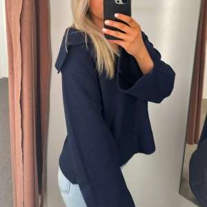 Mörkblå stickad tröja - Säljer en snygg mörkblå stickad tröja med långa ärmar och en offshoulder krage. Perfekt för kyligare dagar och ger en stilren look. Passar bra till jeans eller kjol.❤️🥰 sparsamt använd i bra skick🥰