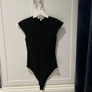 Svart body från H&M - Snygg svart bodysuit från HM i stretchigt tyg🖤Funkar till både jeans, kostymbyxor och kjol✨Endast provad men tyvärr ej lappen kvar! Storlek XS