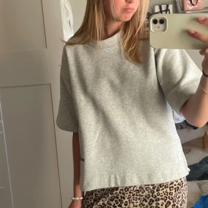 Grå t-shirt - Säljer en enkel och stilren grå t-shirt med normal passform. Perfekt för en avslappnad look.