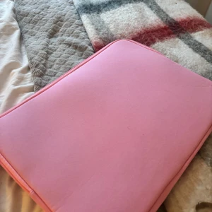 Rosa datorväska med dragkedja - Säljer en söt rosa datorväska med dragkedja. Perfekt för att skydda din laptop med stil. Väskan är enkel och praktisk, lätt att bära med sig. Aldrig använd 