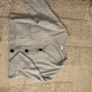 Grå kofta från H&M - Säljer en mysig och snygg grå kofta från H&M. Den har en v-ringad design med knappar framtill och ribbade muddar. Lite oversized vilket är snyggt och trendigt. Säljs för 199kr❤️storlek s 