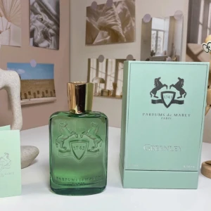 Greenley parfym från Parfums de Marly - Säljer en elegant Greenley parfym från Parfums de Marly. Flaskan är grön med en gyllene kork och har en stilren design med ingraverad logotyp. Förpackningen matchar flaskans gröna ton och har en lyxig känsla. Perfekt för den som söker en sofistikerad doftupplevelse.