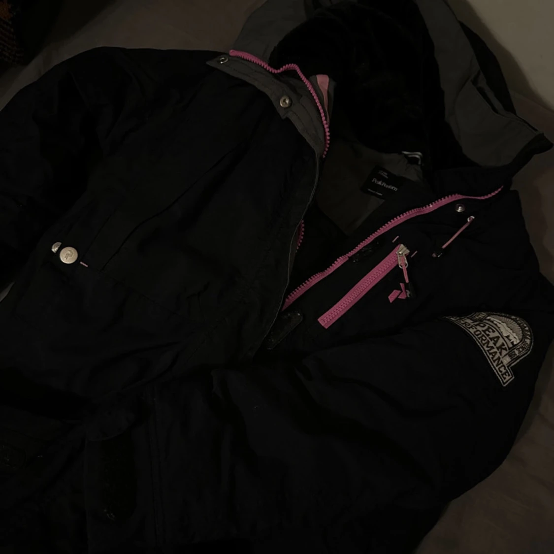 Svart jacka med rosa detaljer från Peak Performance 