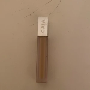 CAIA Cosmetics It's Iconic Concealer - Säljer en CAIA Cosmetics It's Iconic Concealer i nyansen 3N. Den har en praktisk applikator och kommer i en stilren, genomskinlig förpackning med silverlock. Perfekt för att täcka ojämnheter och ge en jämn hudton.