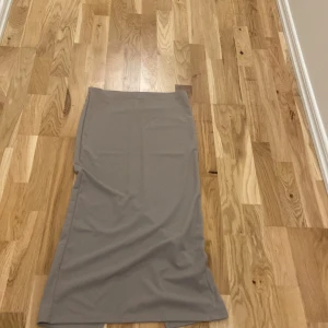 Beige långkjol från 157 - Snygg beige långkjol från 157 i en stilren design. Kjolen har en rak passform och är perfekt för en minimalistisk look. Tillverkad i ett mjukt och bekvämt material som ger en skön känsla hela dagen.Kjolen är aldrig använd. Är i jätte bra skick.