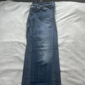 Blå jeans från Replay - Snygga blå jeans från Replay med klassisk femficksdesign och knappgylf. Jeansen har en lätt tvättad look och är perfekta för en avslappnad stil.