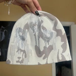 Vit och beige mössa med strassdetaljer - Helt oanvänd mössa från racerworldwide. Unisex.