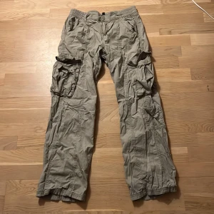 Gröna cargobyxor från H&M Divided - Säljer ett par gröna cargobyxor från H&M Divided. Byxorna har flera praktiska fickor och en elastisk midja för extra komfort. 