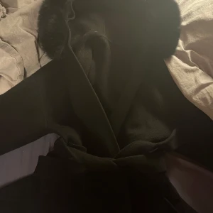 Svart kappa med päls luva från femenina of sweden - Jätte fin svart kappa med en päls luva, nypris ca 3699kr. Den är jätte skön och otroligt vacker. Har andvändts några få gånger och är i väldigt bra skick inga skavanker. Har fått så mycket komplimanger men säljer pga jag har för många jackor. Storlek s från femenina of sweden.Stora fickor som får plats med mycket och en luva som är jätte mysig. Rekommenderar skriv om du har frågor.💕