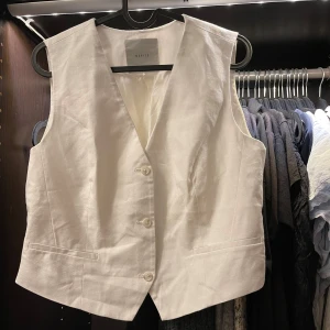 Vit väst från Wakakuu - Snygg vit väst från Mohito med knappar framtill. Den har en klassisk v-ringning & lite tjockare i materialet, toppen är aldrig använd 
