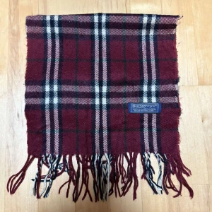 Rutig halsduk från Burberry - Tja! Säljer denna sjukt stilrena halsduken från burberry med rutigt mönster samt en härlig röd färg🔥| unisex och äkta såklart. Nypris ligger runt 4000kr| Längd 153 cm och bredd 30 cm| Tygmatrial Lamull. Tveka inte på att höra av er vid frågor!🤩🤩🤩