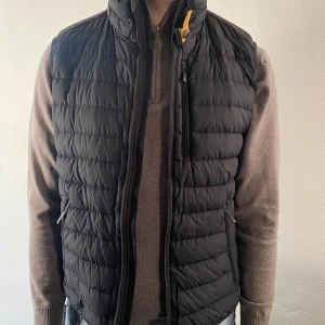 Väst från Parajumpers - Svart väst från Parajumpers till herr i storlek M, normal i storleken. Har en liten reva bak till vänster (se bild nr 3), i överlagt är västen i fint skick. Inköpt för 3500kr 
