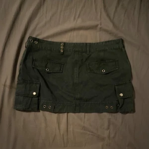 Svart minikjol - As snygg svart mini kjol❤️ Säljer då jag inte riktigt använder mini kjolar❤️ Den är lågmidjade och jag jätte många coola detaljer🤝Det står att det är storlek L men jag skulle säga att det är en M❤️