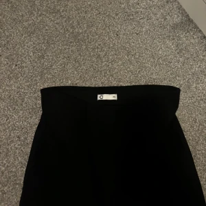 Svart kjol - Säljer en stilren svart kjol i storlek XS. Perfekt för både vardag och fest! Kjolen har en enkel och elegant design som gör den lätt att matcha med olika toppar och accessoarer.