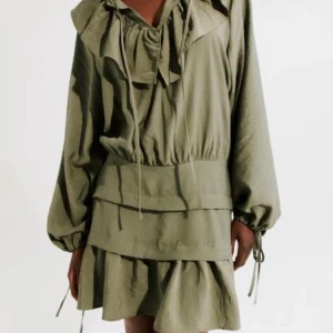 Grön klänning - Säljer min helt nya H&M klänning med prislapp kvar pga för liten. Som ni ser på bilden ska den ha som ”volanger” längst magen vilket det inte är på mig eftersom den är för liten. Råkade ta XS. Nypris 500, helt slut på hm.MER GRÖN IRL ÄN PÅ BILDERNA!!