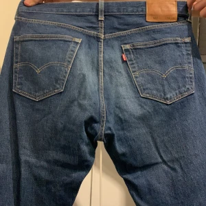 Levis 501 jeans - Klassiska Levis 501 jeans i blå denim med knappgylf och fem fickor. Perfekta för en tidlös stil.