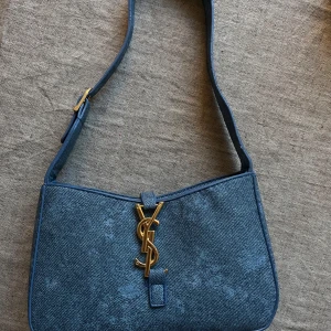 Blå axelväska med guldlogga  - Aldrig använd. 