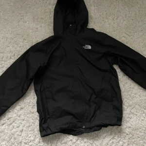 Windbreaker jacka från The north face - Säljer en svart vindjacka från The North Face med huva och dragkedja. Perfekt för blåsiga dagar och har en stilren design med logotyp på bröstet. Minst accepterade pris: 400kr