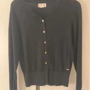 Svart kofta från Lindex  - Snygg svart kofta från Lindex med knappar framtill. Perfekt för lager-på-lager och passar till många olika outfits. Den har långa ärmar och en klassisk design. Använd några få gånger och är i fint skick.