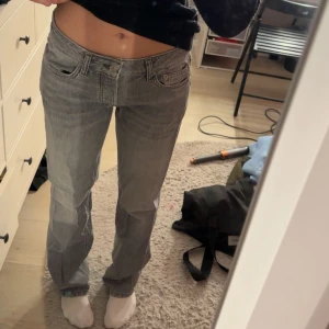 Grå jeansbyxor - Snygga grå jeansbyxor med en klassisk femficksdesign. De har en rak passform och är perfekta för en avslappnad stil. Byxorna har en lågmidjad design och är tillverkade i ett slitstarkt denimtyg.