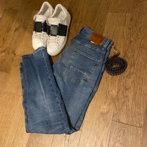 Blå jeans från Tommy Hilfiger - Snygga blå jeans från Tommy Hilfiger med klassisk femficksdesign och en diskret logga på bakfickan. Perfekta för en avslappnad stil. Ny pris 1500. Mitt pris 699