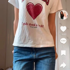 GANNI Vit t-shirt med hjärtmotiv - Snygg vit t-shirt med ett stort rött hjärta och texten 'Have a lovely day' på framsidan. Perfekt för en avslappnad stil.
