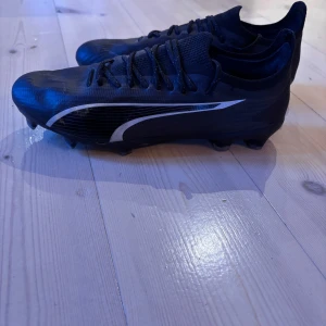 Svarta fotbollsskor från Puma - Säljer ett par svarta fotbollsskor Puma Ultra i  nyskick (har tyvärr inte kartongen kvar) storlek 40,5.