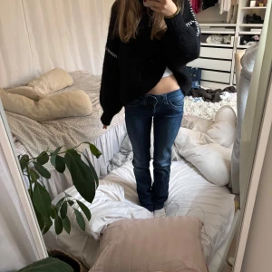 Blå jeans med bootcut - Säljer ett par snygga blå jeans med bootcut. De har en klassisk femficksdesign och en lätt slitning för en avslappnad look. Perfekta för en casual stil.