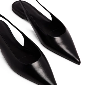 Svarta spetsiga ballerinaskor - Eleganta svarta ballerinaskor med spetsig tå och öppen häl. Perfekta för en stilren look. Tillverkade i skinn för en lyxig känsla. Använda en gång så i mycket fint skick!! Skickas i original förpackning, nypris 499 kr