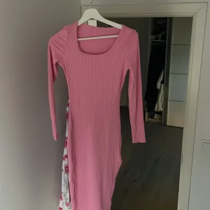 Rosa ribbad klänning - Snygg rosa ribbad klänning med långärmad design och en figurnära passform. Perfekt för en stilren look.