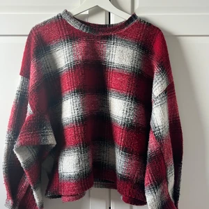 Rutig tröja från Zara - Säljer en snygg rutig tröja från Zara i rött, svart och vitt. Tröjan har långa ärmar och knappar vid ärmsluten. Perfekt för en stilren look! Jättevarm och bekväm (sticks inte). Ett måste till vintern!