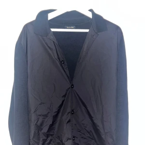 Svart cardigan från Massimo Dutti - Elegant svart cardigan från Massimo Dutti i extrafin bomull. Har långa ärmar och knappar framtill. Perfekt för en stilren look. Storlek M